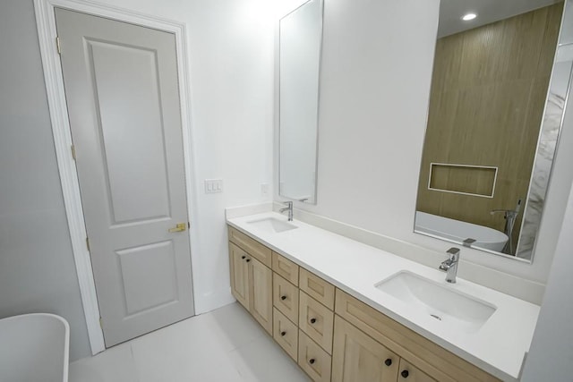 bathroom with tile patterned flooring, a tub to relax in, and vanity