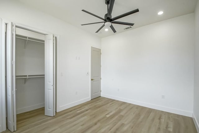 unfurnished bedroom featuring a closet, light wood-type flooring, and ceiling fan