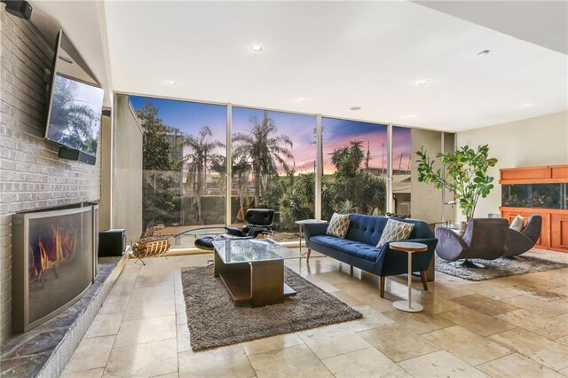 living room featuring a brick fireplace and expansive windows