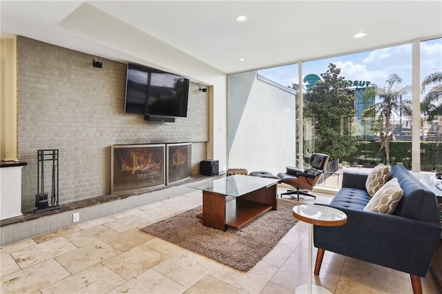 living room with a wall of windows, a fireplace, and plenty of natural light