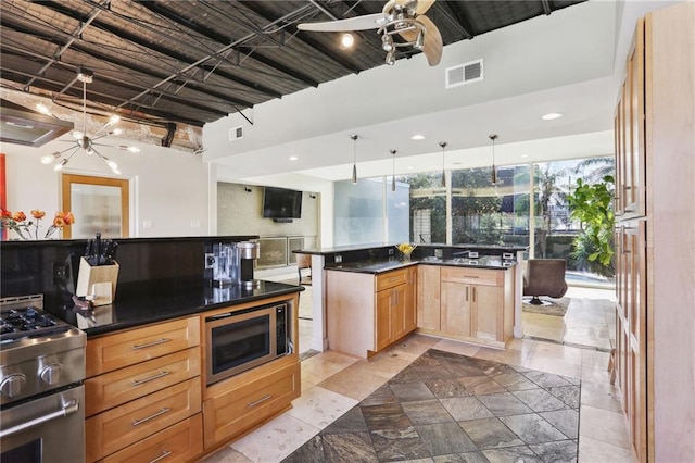 kitchen featuring decorative backsplash, ceiling fan, stainless steel appliances, and decorative light fixtures