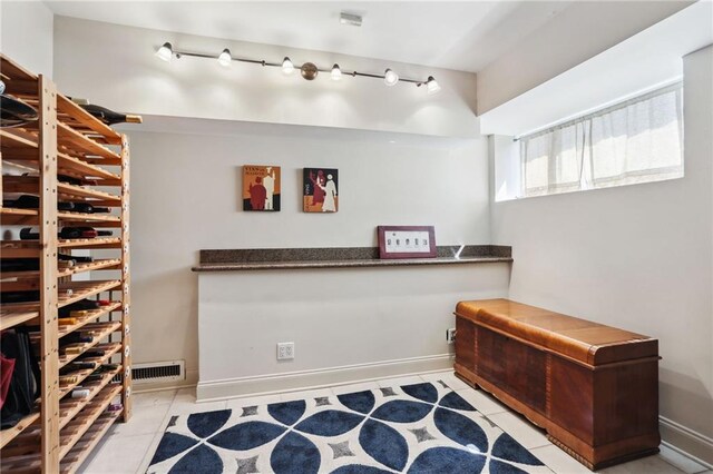 wine room featuring rail lighting and light tile patterned floors