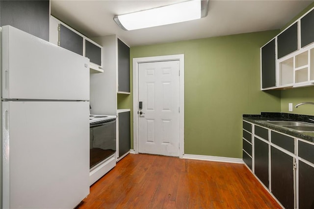 kitchen featuring sink, white fridge, range, and hardwood / wood-style flooring