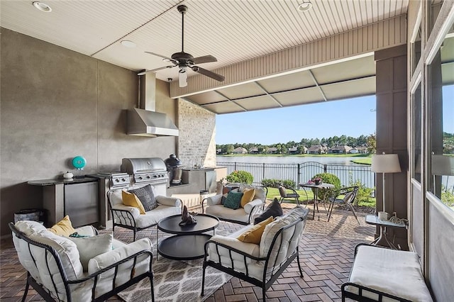 view of patio featuring grilling area, a water view, outdoor lounge area, and exterior kitchen