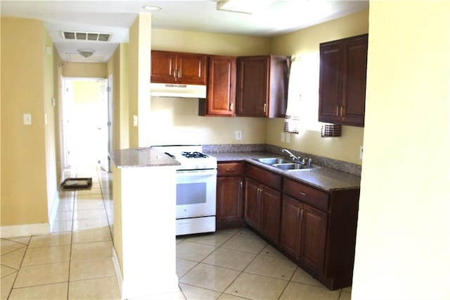 kitchen featuring light tile patterned flooring, white range, sink, and kitchen peninsula