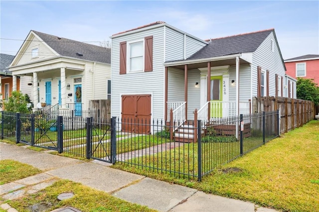 view of front of house featuring covered porch, a front lawn, and a fenced front yard