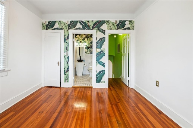unfurnished room featuring hardwood / wood-style floors and baseboards