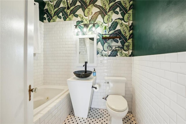 bathroom featuring sink, a relaxing tiled tub, tile patterned floors, tile walls, and toilet