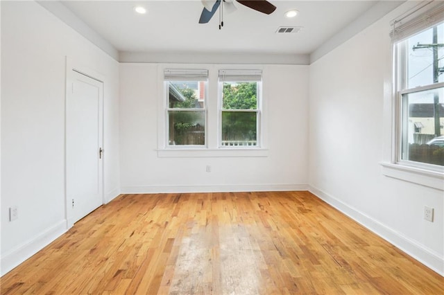 unfurnished room with baseboards, visible vents, ceiling fan, and light wood-style flooring