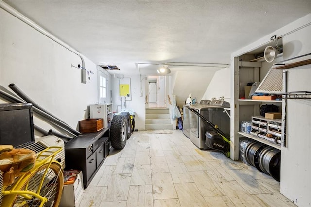 interior space featuring electric panel, a textured ceiling, and independent washer and dryer