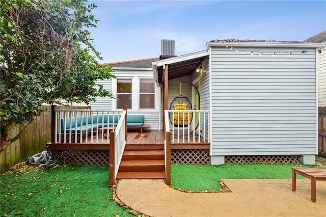 rear view of house with a deck, fence, a patio, and a lawn