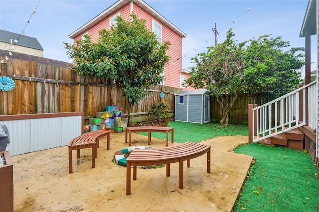 view of patio / terrace with an outdoor structure, a shed, and a fenced backyard