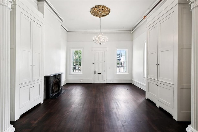 entryway featuring ornamental molding, dark wood-type flooring, and a notable chandelier