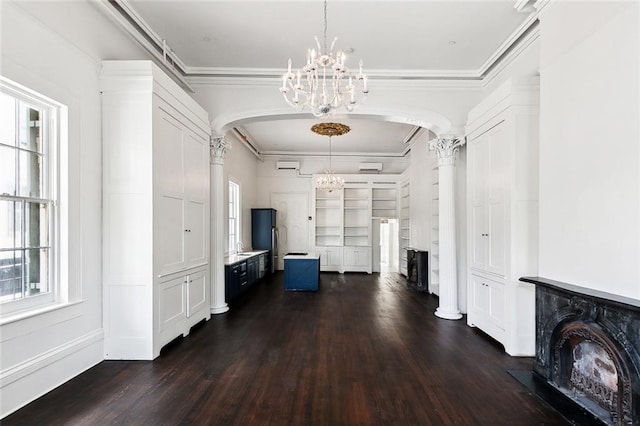 foyer entrance with dark hardwood / wood-style flooring, sink, a notable chandelier, crown molding, and ornate columns