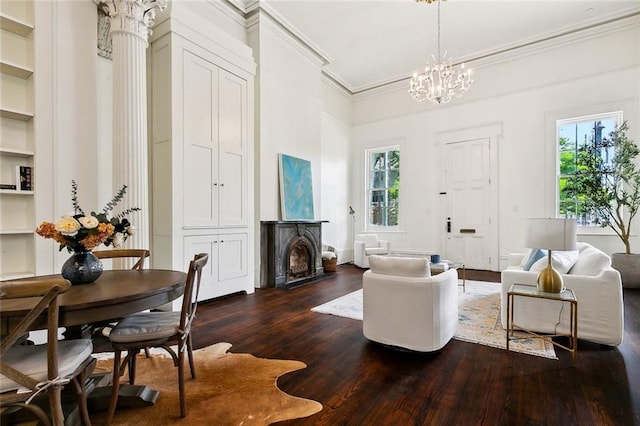 600 Esplanade Ave Unit 1, New Orleans, LA 70116 - living room with ornamental molding, a towering ceiling, built in shelves, dark wood finished floors, and an inviting chandelier