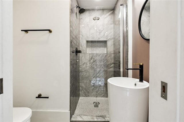 bathroom featuring a tile shower and toilet