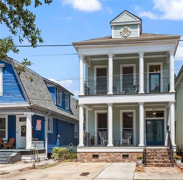 greek revival inspired property with a balcony and a porch