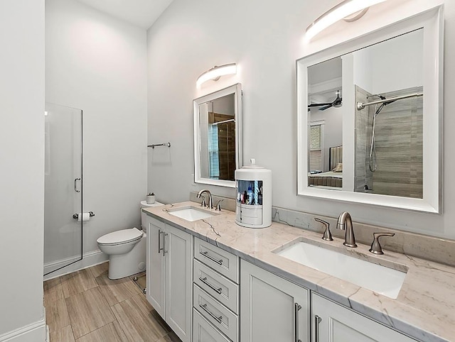 bathroom featuring wood-type flooring, an enclosed shower, ceiling fan, vanity, and toilet