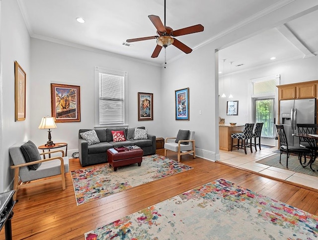 living room with ceiling fan, crown molding, and light hardwood / wood-style floors