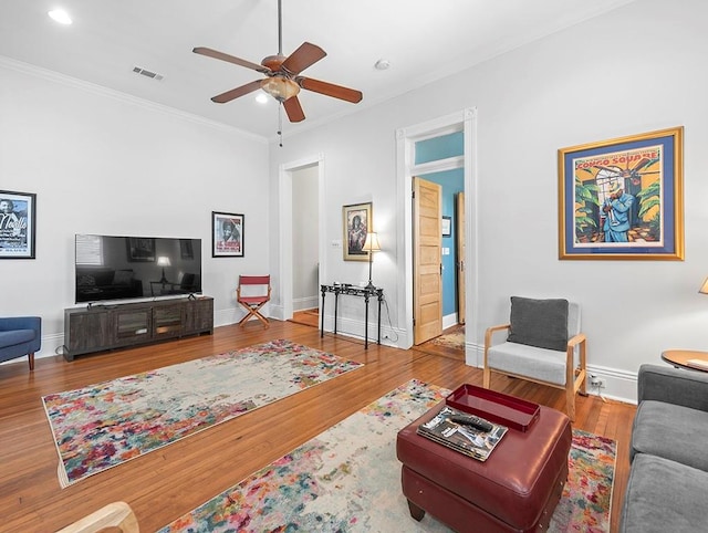 living room with ceiling fan, hardwood / wood-style flooring, and crown molding