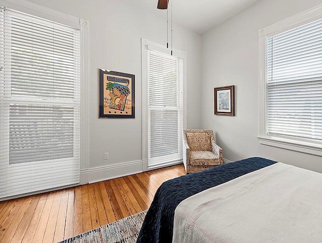 bedroom featuring multiple windows, hardwood / wood-style flooring, and ceiling fan