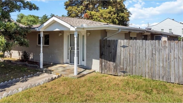 view of front of house with a patio and a front lawn