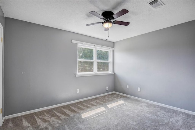 carpeted spare room with ceiling fan and a textured ceiling