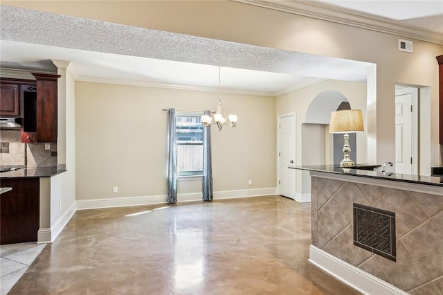 kitchen with crown molding, hanging light fixtures, decorative backsplash, a textured ceiling, and a chandelier