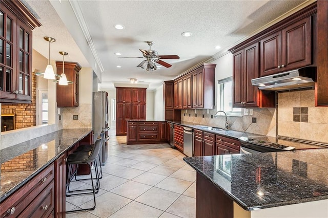 kitchen featuring sink, hanging light fixtures, a textured ceiling, appliances with stainless steel finishes, and ornamental molding