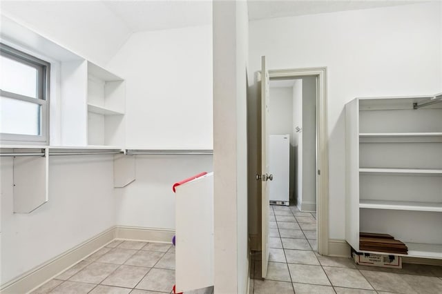 walk in closet with light tile patterned floors and vaulted ceiling