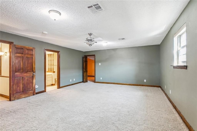 unfurnished bedroom featuring connected bathroom, ceiling fan, light colored carpet, and a textured ceiling