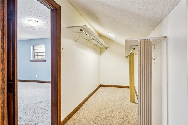 walk in closet featuring lofted ceiling and light carpet