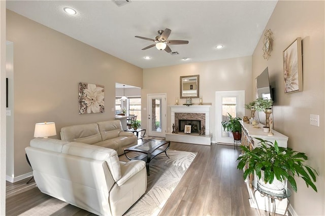 living room featuring dark wood-type flooring and ceiling fan