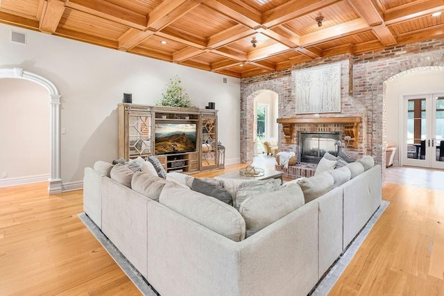 living room with plenty of natural light, light hardwood / wood-style flooring, wooden ceiling, and french doors