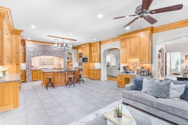 tiled living room with crown molding and ceiling fan