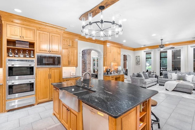 kitchen with black microwave, an island with sink, sink, and stainless steel double oven