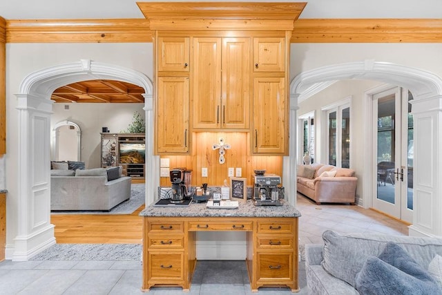 interior space with beamed ceiling, coffered ceiling, french doors, and ornate columns