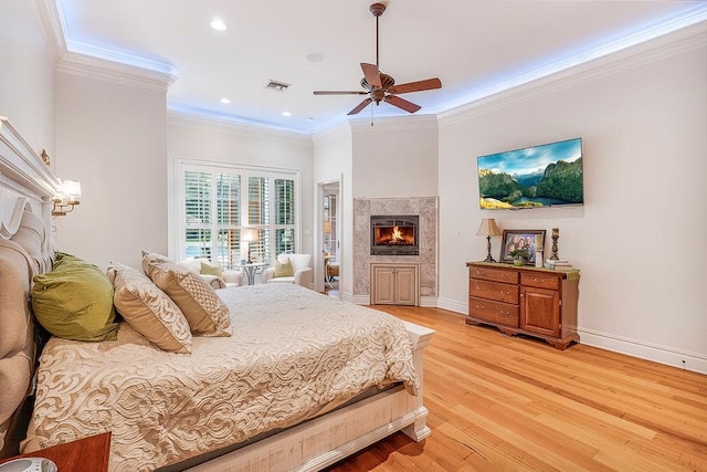 bedroom with hardwood / wood-style floors, ornamental molding, and ceiling fan