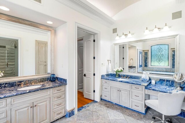 bathroom with vanity, lofted ceiling, and ornamental molding