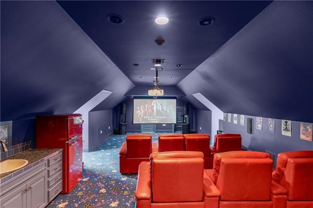 carpeted cinema room featuring lofted ceiling and sink