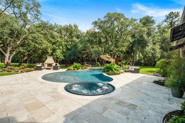 view of swimming pool with a patio and an outdoor stone fireplace