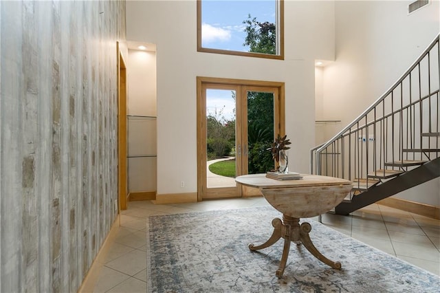 entrance foyer with a towering ceiling and light tile patterned flooring