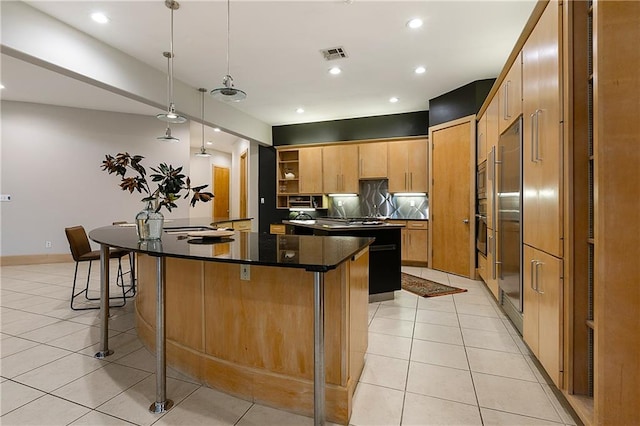 kitchen with stainless steel built in fridge, pendant lighting, light tile patterned flooring, a center island with sink, and a breakfast bar area