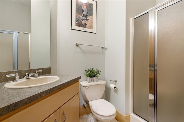 bathroom featuring an enclosed shower, vanity, and toilet