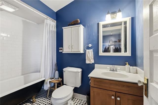 full bathroom featuring vanity, shower / bath combo with shower curtain, toilet, and tile patterned floors