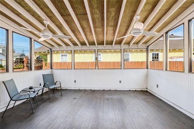 unfurnished sunroom featuring ceiling fan and a healthy amount of sunlight