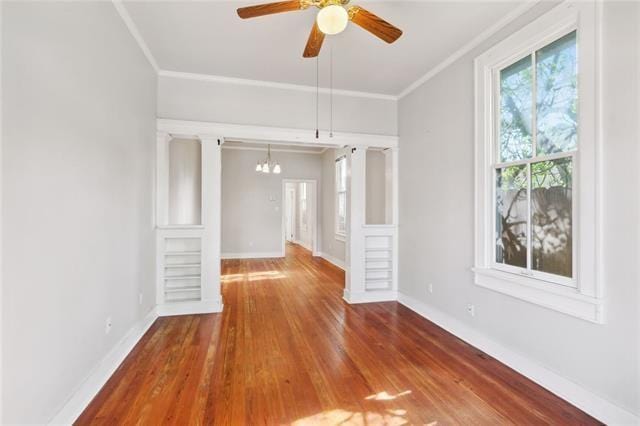 unfurnished living room featuring ornamental molding, hardwood / wood-style floors, and ceiling fan with notable chandelier