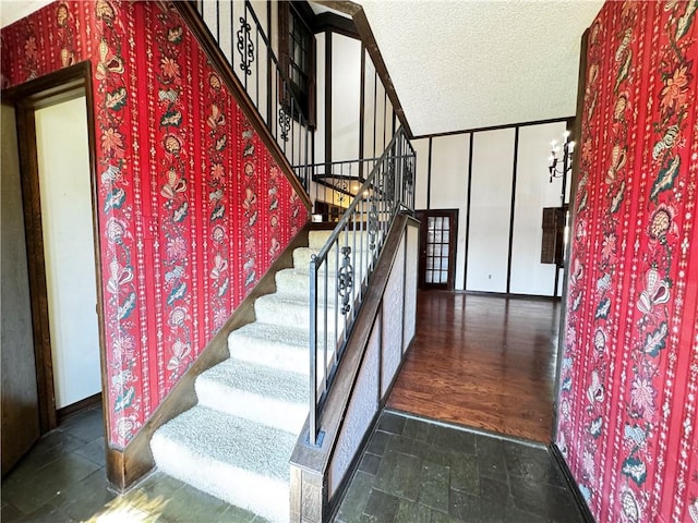 stairs featuring a textured ceiling and wood-type flooring