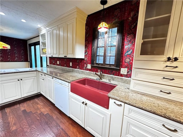 kitchen featuring light stone counters, pendant lighting, sink, dishwasher, and dark hardwood / wood-style floors