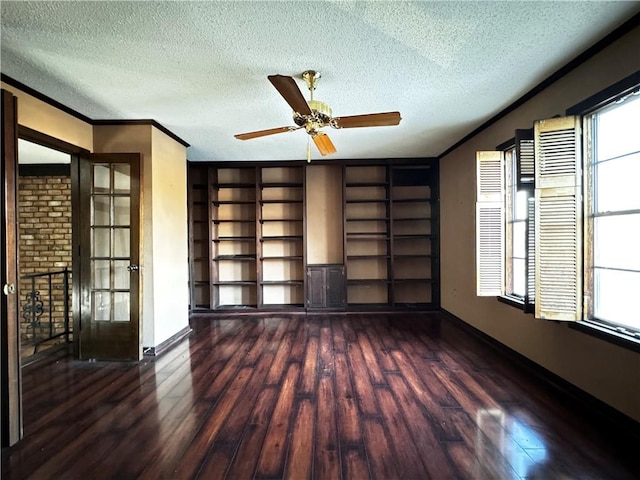 spare room with a textured ceiling, ornamental molding, dark wood-type flooring, and ceiling fan